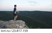 Мужчина приседает на вершине горы. Стоковое видео, видеограф Виктор Аллин / Фотобанк Лори