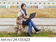 Девушка сидит с ноутбуком на скамейке на заброшенном стадионе. Стоковое фото, фотограф Владимир Арсентьев / Фотобанк Лори