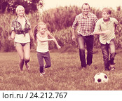Relaxed family of four playing football. Стоковое фото, фотограф Яков Филимонов / Фотобанк Лори