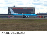 Совершивший посадку самолет Boeing 737-800 (PH-BGA) KLM Royal Dutch Airlines на фоне терминала "F" аэропорта Шереметьево облачным днем (2015 год). Редакционное фото, фотограф Виктор Карасев / Фотобанк Лори