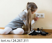 Little girl with socket extender and charging units indoors. Стоковое фото, фотограф Яков Филимонов / Фотобанк Лори