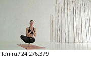 Женщина практикует йогу - Ардха Баддха Падма padangusthasana - балансирование на пальцах ног. Стоковое видео, видеограф Aleksey Popov / Фотобанк Лори