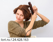 Девушка накручивает волосы на плойку щипцы для завивки волос. Стоковое фото, фотограф Гетманец Инна / Фотобанк Лори