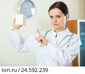Serious female physician warning of faulty drugs. Стоковое фото, фотограф Яков Филимонов / Фотобанк Лори