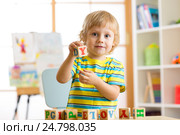 Little preschooler kid boy playing with toy cubes and memorizing letters. Early education and preschool concept. Стоковое фото, фотограф Оксана Кузьмина / Фотобанк Лори