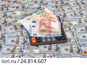Folded stack of russian roubles, euro banknotes and calculator on dollars background. Стоковое фото, фотограф FotograFF / Фотобанк Лори