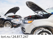 Charging automobile discharged battery by booster jumper cables at winter. Стоковое фото, фотограф Дмитрий Калиновский / Фотобанк Лори