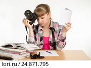 Девушка читает руководства по эксплуатации и самоучители, пытаясь научится фотографировать. Стоковое фото, фотограф Иванов Алексей / Фотобанк Лори