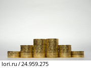 Шесть стопок монет симметрично возрастающей высоты на белом фоне, рябом стоит на ребре 10 рублевая российская монета. Стоковое фото, фотограф Иванов Алексей / Фотобанк Лори