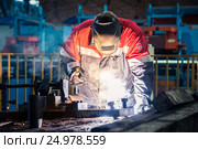 Рабочий электросварщик за работой в заводском цеху. Редакционное фото, фотограф Михаил Михин / Фотобанк Лори