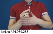 Close up illusionist in red shirt perform magic trick disappear in hands coin. Стоковое видео, видеограф Александр Багно / Фотобанк Лори
