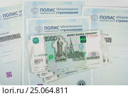 Пачка тысячерублевых купюр лежат на полисах обязательного медицинского страхования. Стоковое фото, фотограф Иванов Алексей / Фотобанк Лори