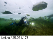 Scubadiver swims under frozen lake, icedivind, Alexandrovsky like, Ukraine (2017 год). Редакционное фото, фотограф Некрасов Андрей / Фотобанк Лори