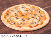 Hot pizza slice with melting cheese on a rustic wooden table. Стоковое фото, фотограф Aleksandr Ryzhov / Фотобанк Лори