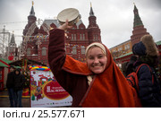 Девушка играет на бубне на Манежной площади в центре города Москвы во время русского праздника Масленица, Россия (2017 год). Редакционное фото, фотограф Николай Винокуров / Фотобанк Лори