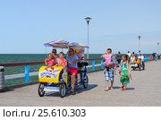 Люди гуляют по пирсу в Паланге, Литва (2015 год). Редакционное фото, фотограф Ольга Коцюба / Фотобанк Лори