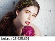 Girl with makeup sequins strewn holding purple brilliant ball. Стоковое фото, фотограф Dmitry Chapurin / Фотобанк Лори