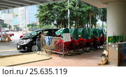 Traditional rickshaws parked at the pier in Hong Kong (2016 год). Редакционное фото, фотограф Chere / Фотобанк Лори