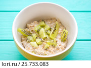 Oatmeal with milk and kiwi in a yellow bowl. Стоковое фото, фотограф Дегтярева Виктория / Фотобанк Лори