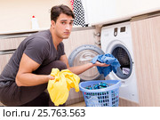 Young husband man doing laundry at home. Стоковое фото, фотограф Elnur / Фотобанк Лори