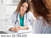 Doctor filling medical form while patient consultation. Стоковое фото, фотограф Людмила Дутко / Фотобанк Лори