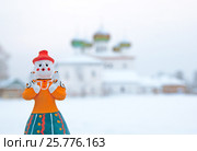 Каргополь. Каргопольская глиняная игрушка "Берегиня" на фоне церкви Благовещения Пресвятой Богородицы (2009 год). Редакционное фото, фотограф Румянцева Наталия / Фотобанк Лори