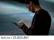 Мужчина читает священную книгу Коран в молельном зале Московской соборной мечети, Россия (2017 год). Редакционное фото, фотограф Николай Винокуров / Фотобанк Лори