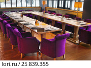 RUSSIA, MOSCOW - DEC 28, 2014: Hall with served tables with plate Reserved and violet soft armchairs in restaurant Siren (Lilac) in Sokolniki park. Редакционное фото, фотограф Losevsky Pavel / Фотобанк Лори