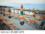 Empty beach with folded umbrellas and lounges on coastline in evening. Стоковое фото, фотограф Losevsky Pavel / Фотобанк Лори