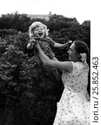 Молодая женщина держит маленькую дочь на вытянутых руках, 1959 год (без ретуши) Стоковое фото, фотограф Ирина Борсученко / Фотобанк Лори