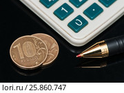 Десятирублёвые монеты, калькулятор и авторучка на чёрном фоне. Стоковое фото, фотограф Игорь Низов / Фотобанк Лори