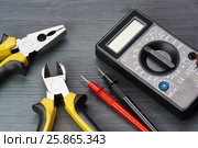 Multimeter and side cutters and pasatize on a dark wooden background. Стоковое фото, фотограф Alexander / Фотобанк Лори