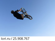 Extreme biker black t-shirt, blue jeans and a helmet, doing a somersault in aeromat (2016 год). Редакционное фото, фотограф Светлана Додух / Фотобанк Лори
