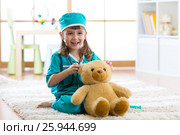 Cute kid girl playing doctor with plush toy at home. Стоковое фото, фотограф Оксана Кузьмина / Фотобанк Лори