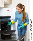 Cheerful smiling glad adult girl removing snuff in oven. Стоковое фото, фотограф Яков Филимонов / Фотобанк Лори