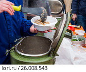 Повар накладывает порцию гречневой каши из армейского термоса. Стоковое фото, фотограф Вячеслав Палес / Фотобанк Лори