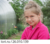 Девочка в красной кофте с хитрой улыбкой на лице. Стоковое фото, фотограф Александр Романов / Фотобанк Лори