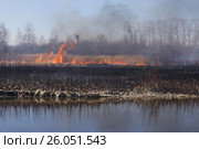 Весна. Берег реки во льду. Сгоревшая трава. Огонь. На заднем плане водонапорная башня. Стоковое фото, фотограф Нина Карымова / Фотобанк Лори