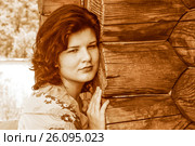 Молодая женщина в платке на фоне деревянного дома. Стоковое фото, фотограф Сергеев Валерий / Фотобанк Лори