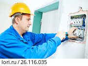 electrician installing switching electric actuator in fuse box. Стоковое фото, фотограф Дмитрий Калиновский / Фотобанк Лори