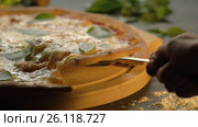 Supreme Delicious Pizza lifted slice with melted cheese and Basil leaves on wooden cutting boardand, slow motion. Стоковое видео, видеограф Вячеслав Позднышев / Фотобанк Лори