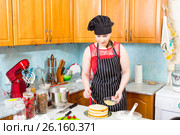 Молодая женщина на кухне пропитывает верхний бисквит торта с помощью кулинарной кисточки. Стоковое фото, фотограф Сергей Дубров / Фотобанк Лори
