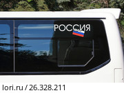 Надпись "РОССИЯ" и триколор на черном стекле белого туристического автобуса. Стоковое фото, фотограф Александр Степанов / Фотобанк Лори