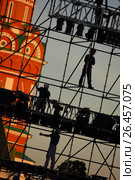 Diagonal view on workers on stage construction levels at Moscow Red Square in front of Vasiliy Blazhenniy Cathedral. Workers shadow figures on staging construction. Pop music stage under construction (2005 год). Редакционное фото, фотограф Mikhail Leonov / Фотобанк Лори