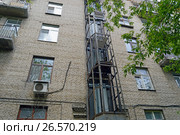 Монтаж шахты внешнего лифта на стене старого пятиэтажного трёхподъездного кирпичного жилого дома. Москва, улица Панфилова, 18а (2017 год). Стоковое фото, фотограф Александр Замараев / Фотобанк Лори
