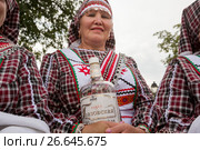 Женщина а удмуртской национальной одежде встречает гостей хлебом-солью и чаркой водки во время празднования удмуртского праздника «Гербер» (2017 год). Редакционное фото, фотограф Николай Винокуров / Фотобанк Лори