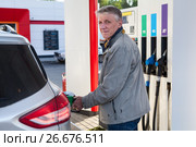 Портрет пожилого мужчины, заправляющего свой автомобиль на АЗС. Стоковое фото, фотограф Кекяляйнен Андрей / Фотобанк Лори