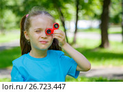 Девочка подставила спиннер к глазу. Стоковое фото, фотограф Иван Карпов / Фотобанк Лори