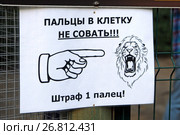 Объявление на решетке клетки в контактном зоопарке "Пальцы в клетку не совать! Штраф 1 палец" (2017 год). Редакционное фото, фотограф Александр Замараев / Фотобанк Лори