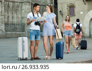 Couple with luggage checking direction in map. Стоковое фото, фотограф Яков Филимонов / Фотобанк Лори
